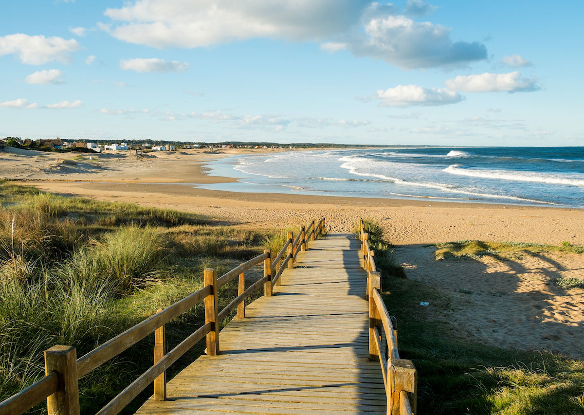 Wooden-boarwalk-in-the-grass-leading-to-a-sandy-beach-in-Uruguay-1200x853.jpg