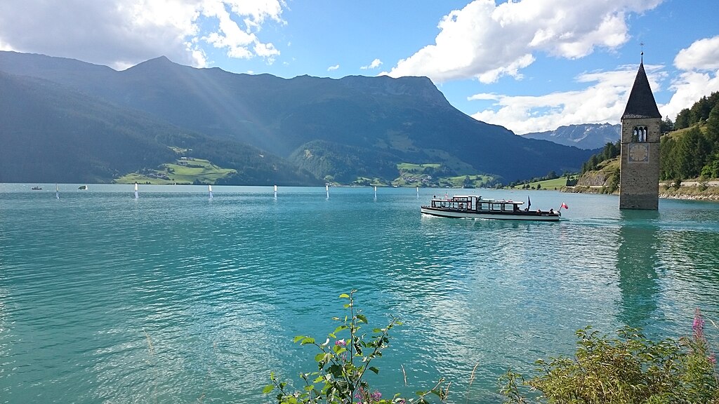 1024px-Reschensee_with_Graun_Church_tower_and_boat.jpg